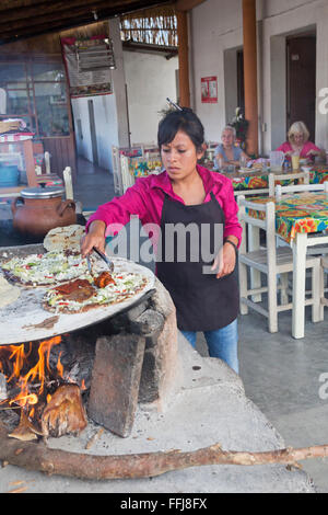 Matatlán Santiago, Oaxaca, Mexique - un travailleur fait tlayudas sur un comal dans un restaurant d'Oaxaca. Banque D'Images