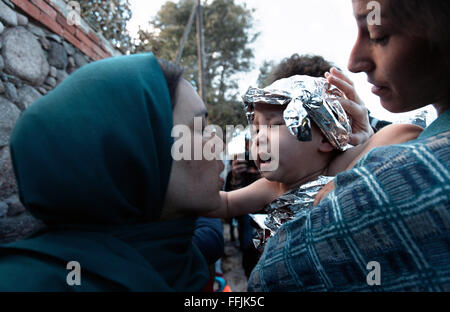 Les médecins à aider les réfugiés après avoir traversé les 7 kilomètres de distance du littoral turc à Lesbos, enveloppant le bébé mouillé Banque D'Images