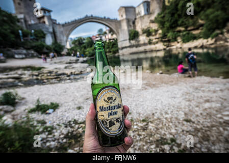 Mostarsko Pivo bière avec plus célèbre de la ville de Mostar Stari Most (Vieux Pont) sur la rivière Neretva, Bosnie-Herzégovine Banque D'Images