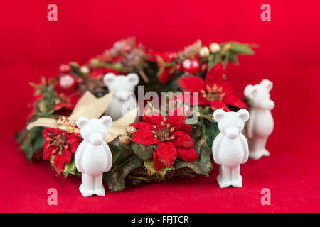 Beau petit ours en plâtre souhaite Joyeux Noël, fond rouge Banque D'Images