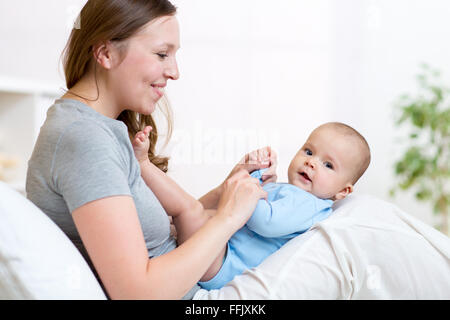 Mère a l'air et jouer avec bébé. Le bonheur de la maternité. Banque D'Images