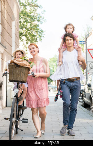 Famille avec deux enfants de marcher en ville Banque D'Images