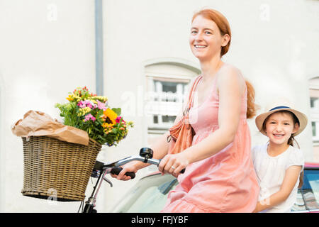 Mère et fille à vélo en ville Banque D'Images