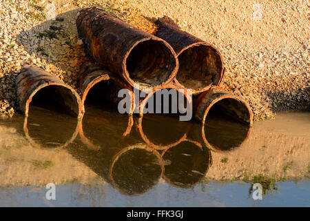 Détail de tuyaux qui libèrent de l'eau et les liquides dans une rivière. Banque D'Images