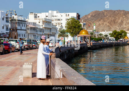 Les hommes en costume traditionnel omanais sur la Corniche (Promenade) à Muttrah, Muscat, Sultanat d'Oman Banque D'Images