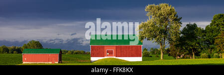 Un paysage couleur photo montrant barn contre un sombre ciel bleu après un orage d'été en Ontario, Canada. Banque D'Images