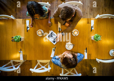 Friends using digital tablet in restaurant Banque D'Images