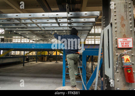 Assembler les travailleurs les diverses composantes de la conception modulaire du boîtier dans une usine dans le Brooklyn Navy Yard, à New York, le jeudi 11 février, 2016. En raison de la hausse des loyers et de la nécessité d'un espace spécialisé l'usine va fermer après après ce travail, le logement pour le développement de Spring Creek Néhémie. Steiner Studios, un autre locataire à la Brooklyn Navy Yard sera prise en charge de l'espace. (© Richard B. Levine) Banque D'Images