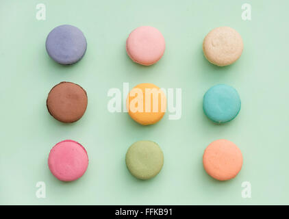 Biscuits macaron français colorés doux pastel sur fond de menthe, vue du dessus Banque D'Images