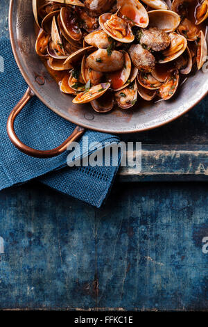 Coquillages de persil et vongole sauce tomate sur fond bleu Banque D'Images