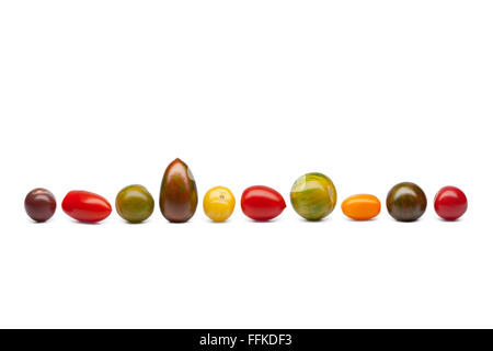 Colorés frais tomates sauvages dans une rangée à fond blanc Banque D'Images