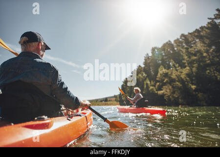 Image senior & vie de couple de kayak dans le lac sur une journée ensoleillée. Les kayakistes dans le lac de canotage. Banque D'Images