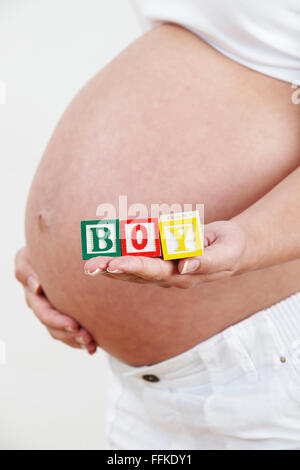 Close Up of pregnant woman Holding Blocks Spelling BOY Banque D'Images