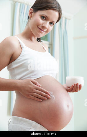 Femme enceinte ventre hydratant Banque D'Images