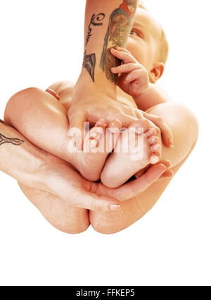 Une Jeune Mere En Tatouage Sur Ses Bras Tenant Les Pieds De Son Bebe Dans Ses Mains Pour L Arriere Plan Blanc Photo Stock Alamy