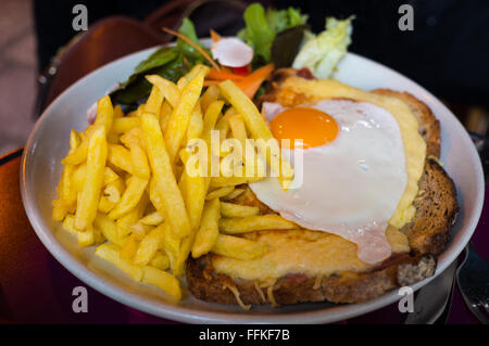 Croque Madame servie avec frites et salade Banque D'Images