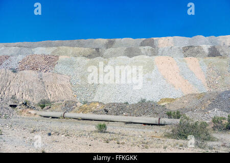 Les couches de résidus à épaulement gravier délicatement colorée par des minéraux rejetés rencontrez sol du désert au périmètre extérieur de la mine de la Mission Banque D'Images