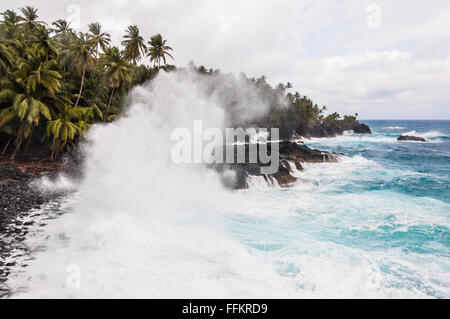 Broyage des grosses vagues sur le rivage d'une île tropicale avec des palmiers au cours d'une tempête. Praia Piscina - Sao Tomè et Principe. Banque D'Images