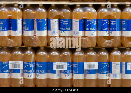 Valeur budget bouteilles de boisson gazeuse orange empilés dans un magasin. Banque D'Images