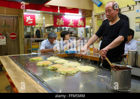 Chef de style japonais d'Hiroshima okonomiyaki (crêpe salé) à l'intérieur restaurant Sarashina Okonomimura à Hiroshima Banque D'Images