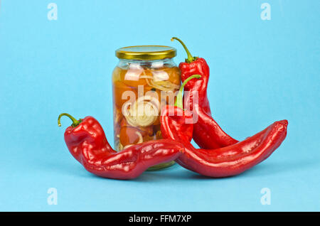 Halfed rouge en boîte de tomates et poivrons grand brillant sur fond bleu Banque D'Images