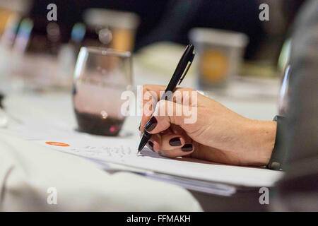 Une femme prend des notes pendant une conférence d'affaires Banque D'Images