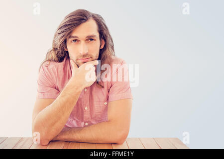 Image composite de Young man with hand on chin Banque D'Images