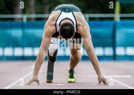 Jeune athlète runner commencent à handicap à stade sprint Banque D'Images