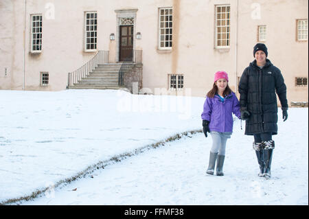 Mère et fille marcher dans la neige au Château de tambour dans l'Aberdeenshire, en Écosse. Banque D'Images