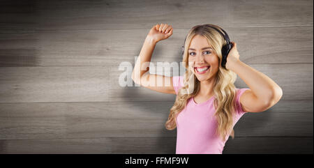 Image composite de portrait d'une belle femme danser avec des écouteurs Banque D'Images