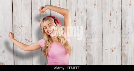 Image composite de belle femme danser avec des écouteurs Banque D'Images