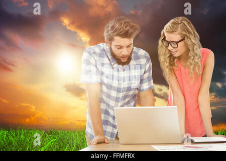 Image composite de l'homme à l'aide d'ordinateur portable tout en discutant avec woman at desk Banque D'Images