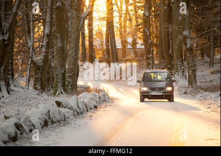 Voiture roulant dans la neige dans Dunecht Estate dans l'Aberdeenshire, en Écosse. Banque D'Images