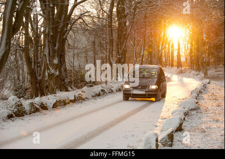 Voiture roulant dans la neige dans Dunecht Estate dans l'Aberdeenshire, en Écosse. Banque D'Images