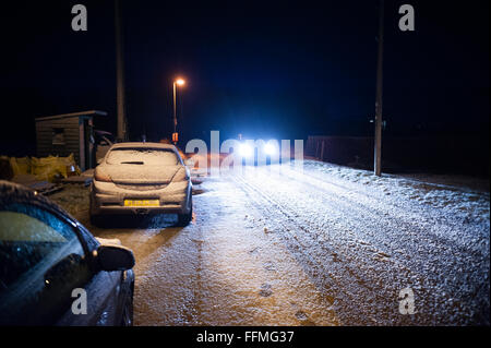 Voitures garées sur une route enneigée de nuit dans Leslie dans l'Aberdeenshire, en Écosse, le 29 décembre 2011. Banque D'Images