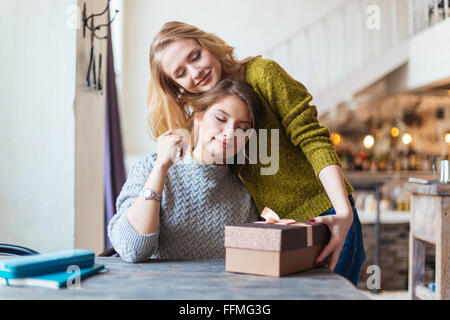 Cadeau femme donnant à son amie in cafe Banque D'Images