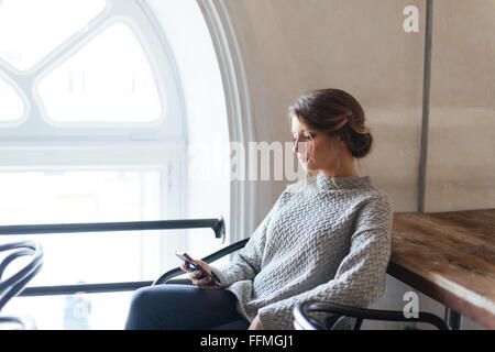 Young Beautiful woman using smartphone in cafe Banque D'Images