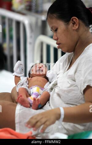 Manille, Philippines. 16 Février, 2016. Une mère porte son enfant nouveau-né à l'intérieur de la maternité de l'Hôpital Memorial Dr. Jose Fabella à Manille, Philippines, 16 février 2016. Le ministère philippin de la Santé a informé les femmes à ne pas tomber enceinte jusqu'à cette année on en sait davantage sur la transmission de Zika virus qui cause des anomalies des naissances en Amérique latine, en dépit du fait que les Philippines' seul cas signalé de Zika était il y a quatre ans. Credit : Rouelle Umali/Xinhua/Alamy Live News Banque D'Images