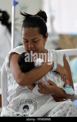 Manille, Philippines. 16 Février, 2016. Une mère porte son enfant nouveau-né à l'intérieur de la maternité de l'Hôpital Memorial Dr. Jose Fabella à Manille, Philippines, 16 février 2016. Le ministère philippin de la Santé a informé les femmes à ne pas tomber enceinte jusqu'à cette année on en sait davantage sur la transmission de Zika virus qui cause des anomalies des naissances en Amérique latine, en dépit du fait que les Philippines' seul cas signalé de Zika était il y a quatre ans. Credit : Rouelle Umali/Xinhua/Alamy Live News Banque D'Images