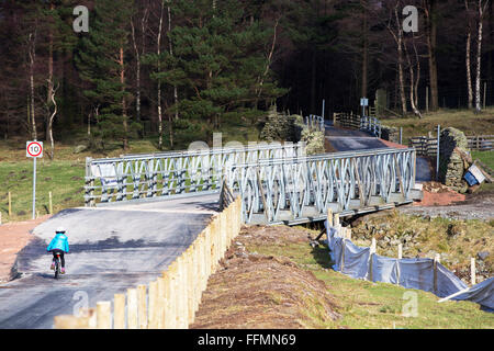 Storm Desmond fait des ravages à travers Cumbria avec des inondations et la destruction. L'A591, la route principale entre Ambleside et Keswick était coupé en deux, comme une grande partie de la route ont été emportés. Il est susceptible d'être de six mois au moins avant la route est ouverte. Dans le même temps un chemin temporaire a été construit principalement sur une ancienne piste forestière, et Bsiley ponts ont été mis en place pour les cyclistes et un service d'autobus peut fonctionner. Il ouvre ses portes le mardi 16 février. Banque D'Images