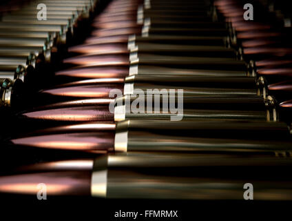 Une macro vue rapprochée d'une rangée de rayures régulières des balles en laiton et cuivre sur un fond noir Banque D'Images