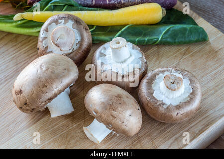 Faire revenir les champignons avec rainbow carottes et blettes en arrière-plan Banque D'Images