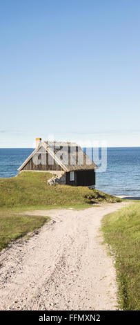 Chalets de pêche contre le soleil et plage de galets en Osterlen, Skane / Scania, la Suède. La Scandinavie. Banque D'Images