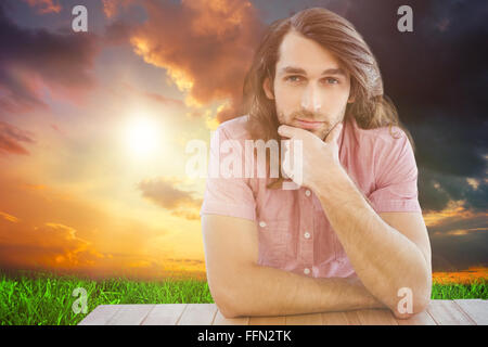 Image composite de Young man with hand on chin Banque D'Images