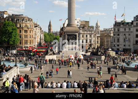 Trafalgar Square au printemps montrant la foule au pied de la Colonne Nelson et de Big Ben au loin. Banque D'Images