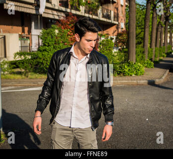 Jeune homme de cracher dans la rue. Summertime Banque D'Images