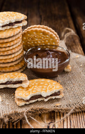 Les cookies au chocolat avec la crème à l'intérieur sur fond de bois Banque D'Images