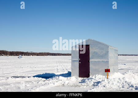 Ice shanty assis sur un lac gelé avec un Garder hors de juxtaposé aux paysage stérile. Copier l'espace. L'humour. Banque D'Images