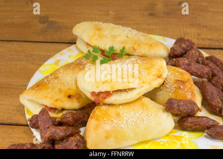 Avec de petits pains pizza pepperoni et saucisses sur une assiette Banque D'Images