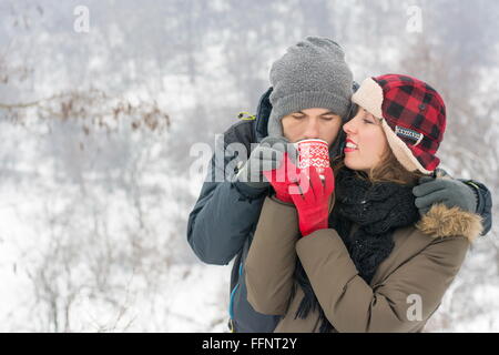 Young Caucasian couple partager plateau extérieur en hiver Banque D'Images